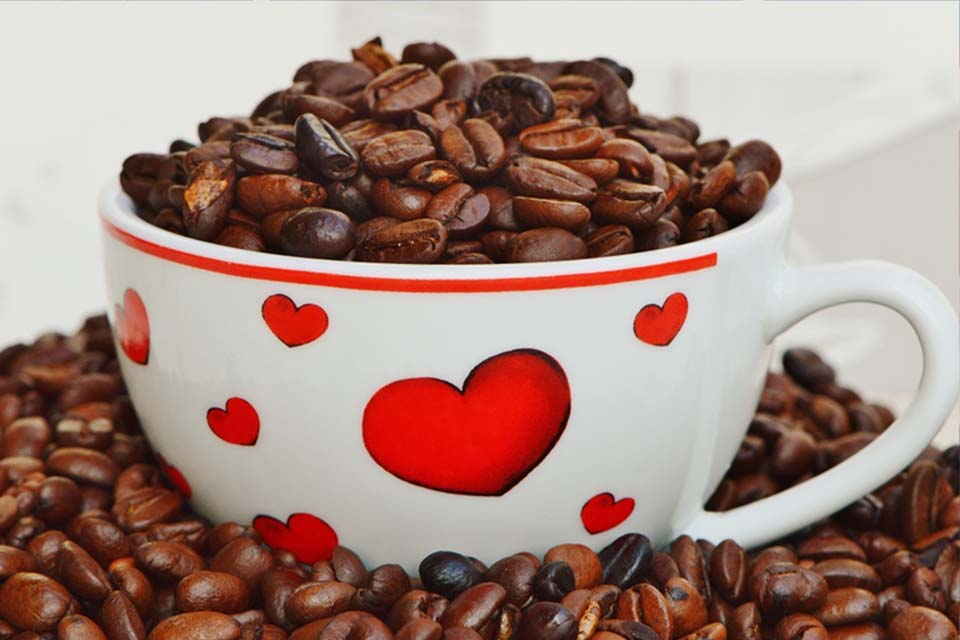 Donate to Coffee Party USA - Photo of a coffee cup decorated with hearts and overflowing with coffee beans.